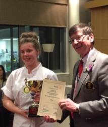 Robyn receives her trophy and certificate from the District Governor